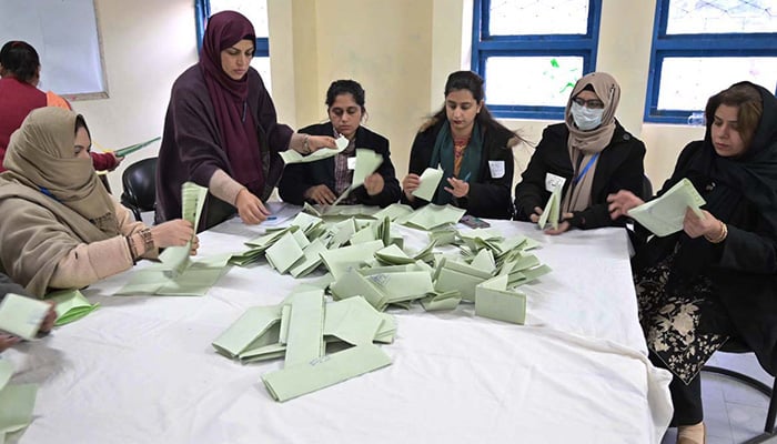 Polling officials count votes at a polling station in F-6 area, Islamabad, during general elections on February 8, 2024. — APP