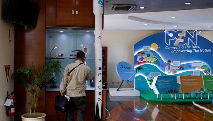 A man stands next to a model of SpaceX’s Falcon 9 rocket at the office of Pasifik Satelit Nusantara, an Indonesia’s satellite-based telecommunication firm, in Jakarta, Indonesia, January 15, 2024. — Reuters