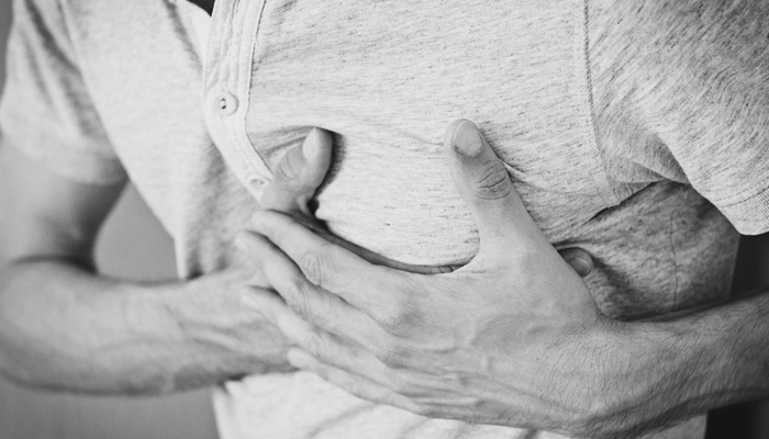 This representational image shows a person holding a chest due to pain. — Pexels