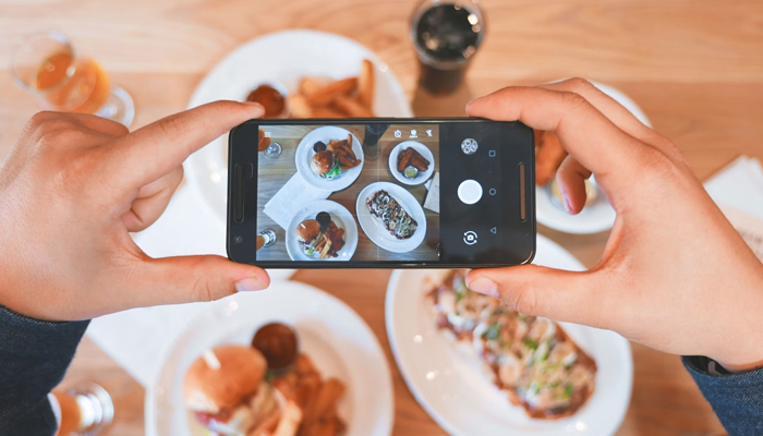 A representational image of a person taking a photograph of food. — Unsplash