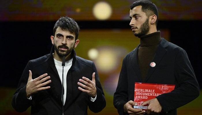 Israeli director Yuval Abraham (left) and Palestinian director Basel Adra speak on stage after receiving the Berlinale documentary award for No Other Land during the awards ceremony of the 74th Berlinale International Film Festival, on February 24, 2024, in Berlin. — AFP