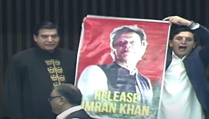 PTI Chairman Gohar Khan holding a banner party founder Imran Khan after signing the role of member register. — Screengrab/PTV News