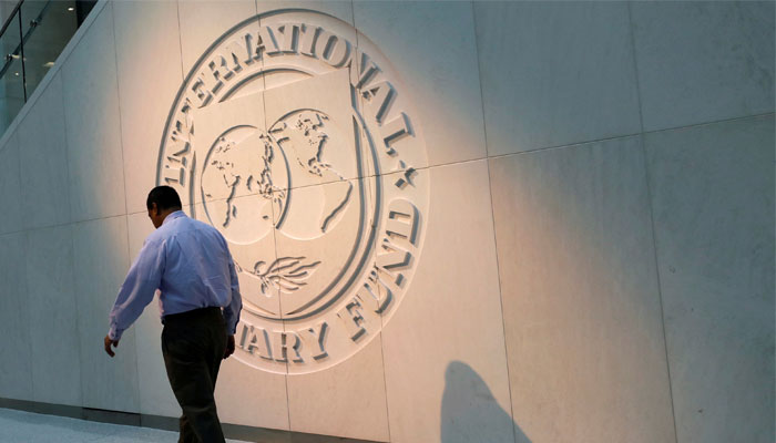 A man walks past the IMF logo outside its headquarters in Washington DC. — Reuters/File
