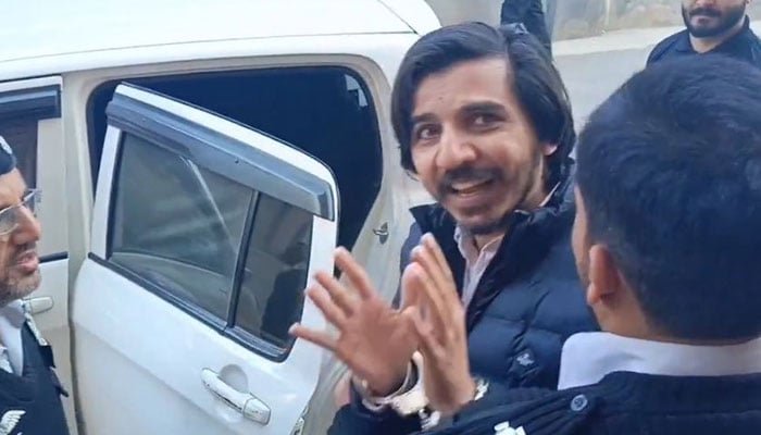 Journalist Asad Toor can be seen leaving an Islamabad court in police custody on February 27, 2024. — Screengrab/X/@ImaanZHazir