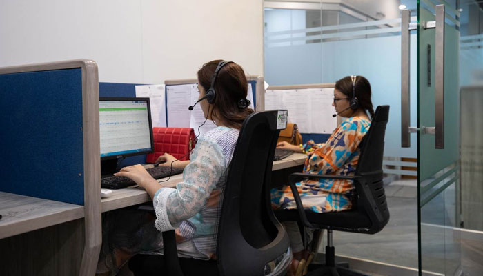 Employees at health tech company Sehat Kahani answer calls at the main office in Karachi, Pakistan on April 14, 2022. — Reuters