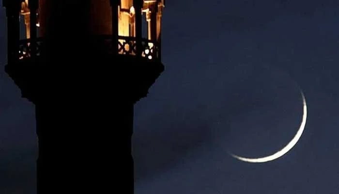 A new crescent seen through a telescope shines beside the tower of a mosque. — Reuters/File