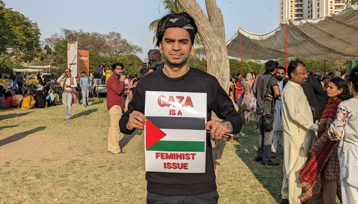 A man holding a placard in Aurat March at Frere Hall Karachi on March 8, 2024. — Author