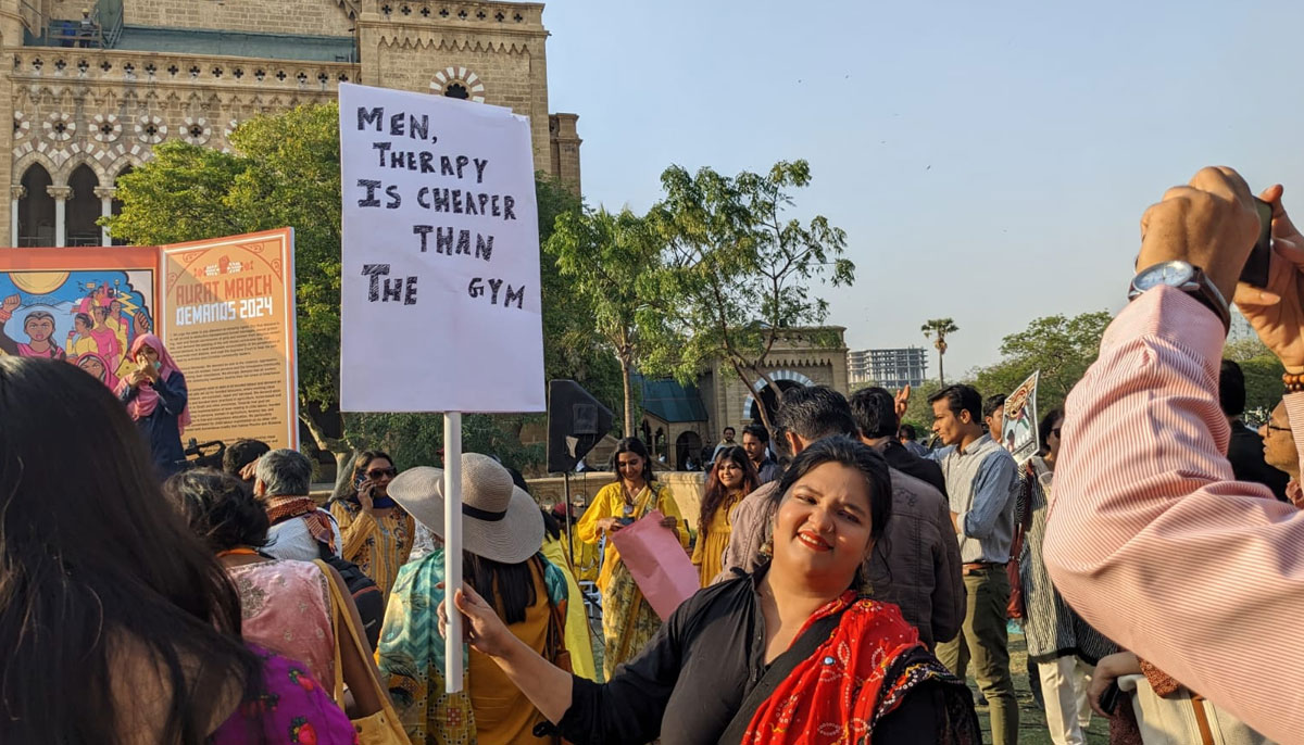 A woman holding a placard in Aurat March at Frere Hall Karachi on March 8, 2024. — Author