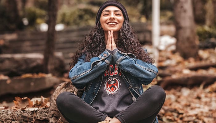 A woman meditating in a park. — Unsplash