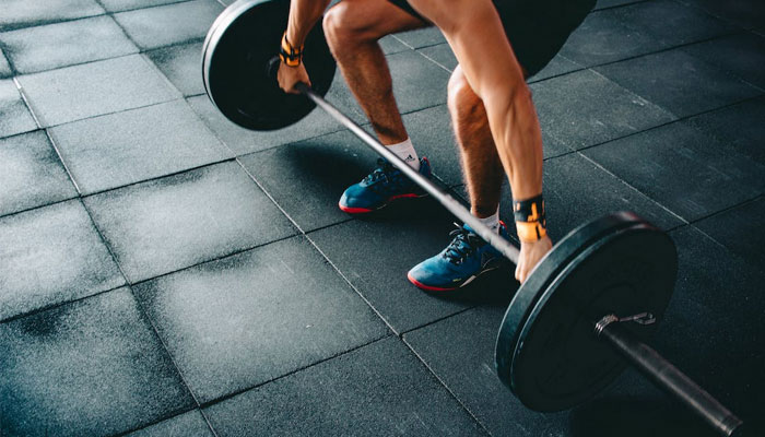 Un hombre realiza entrenamiento de fuerza mediante levantamiento de pesas.  -Pexel