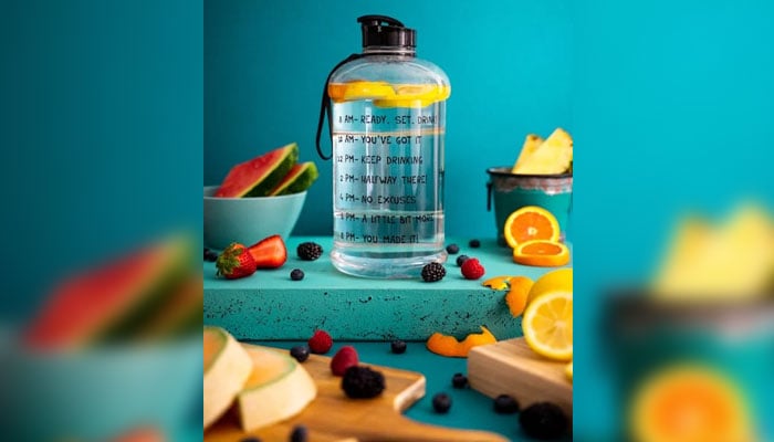 Esta imagen muestra una botella grande llena de agua y limones.  -Pexels