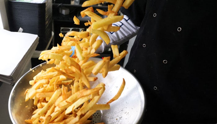 Bertrand Balasi, manager of Tram de Boitsfort stand, prepares fries in Brussels, Belgium February 4, 2022. —Reuters