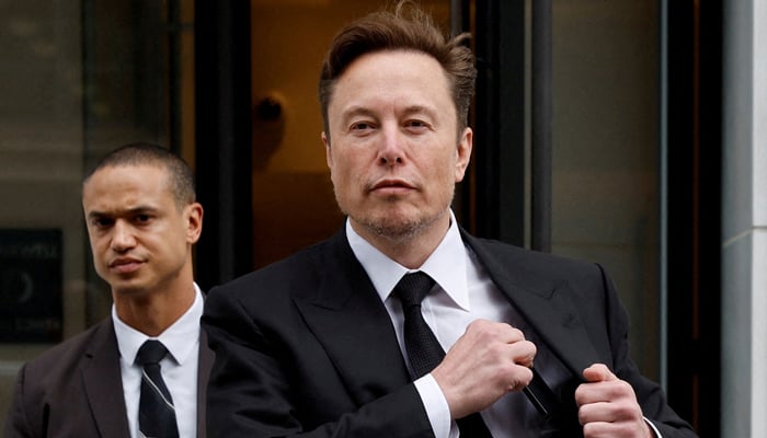 Tesla CEO Elon Musk and his security detail depart the companys local office in Washington on January 27, 2023. — Reuters