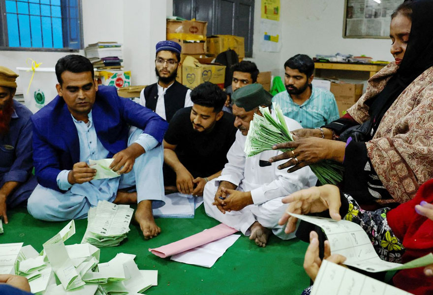 Officers at a polling station in Karachi count votes after end of polling time. — Reuters/File