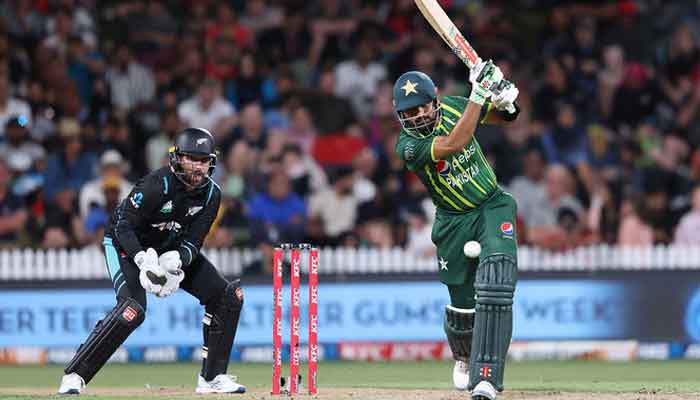 Babar Azam bats while being watched by New Zealand wicketkeeper Devon Conway (L) during the second Twenty20 international cricket match between New Zealand and Pakistan at Seddon Park in Hamilton on January 14, 2024. —AFP