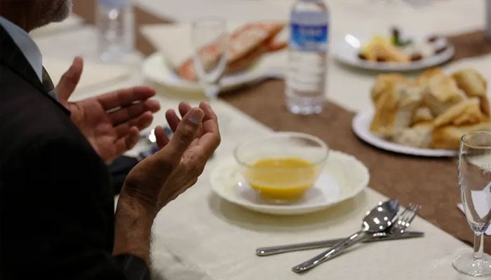 Muslim man breaks fast at ceremony during Muslim fasting month of Ramadan in Cologne.—Reuters/File
