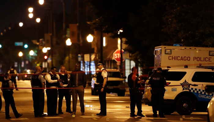 Police officers investigate at the scene of a shooting outside a funeral home in Chicago, Illinois. — AFP/File