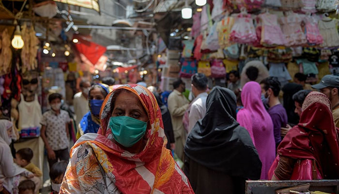 People shop at a local market in Rawalpindi. — AFP/File