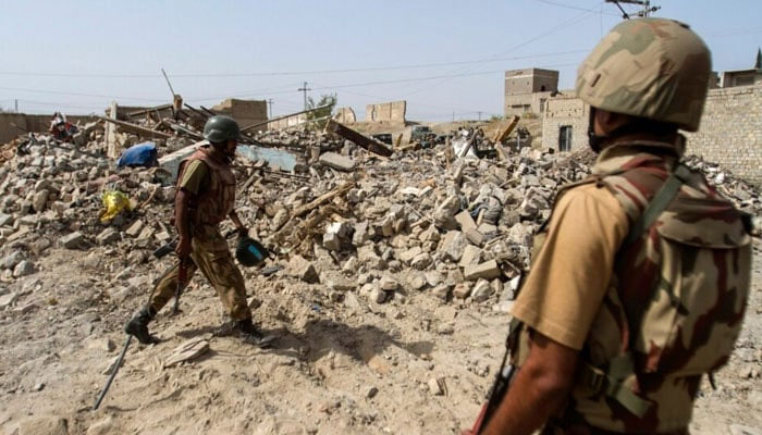Soldiers stand near debris of a house which was destroyed during a military operation against militants in the town of Miranshah, North Waziristan out July 9, 2014. — Reutres