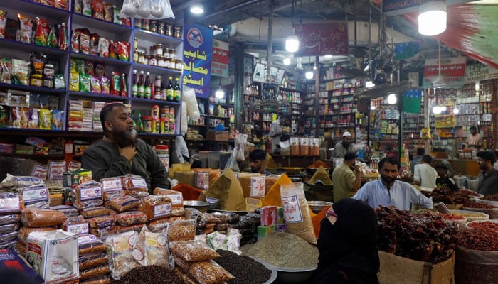 A customer speaks with a shopkeeper selling grocery items at a market in Karachi, Pakistan June 8, 2023. — Reuters