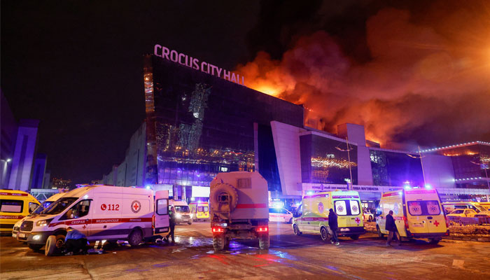 Vehicles of Russian emergency services are parked near the burning Crocus City Hall concert venue following a reported shooting incident, outside Moscow, Russia, March 22, 2024. — Reuters