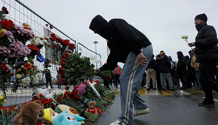 People lay flowers at a makeshift memorial to the victims of a shooting attack at the Crocus City Hall concert venue in the Moscow Region, Russia, March 23, 2024. — Reuters