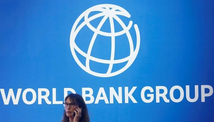 A participant stands near a logo of World Bank at the International Monetary Fund - World Bank Annual Meeting 2018 in Nusa Dua, Bali, Indonesia, October 12, 2018. — Reuters
