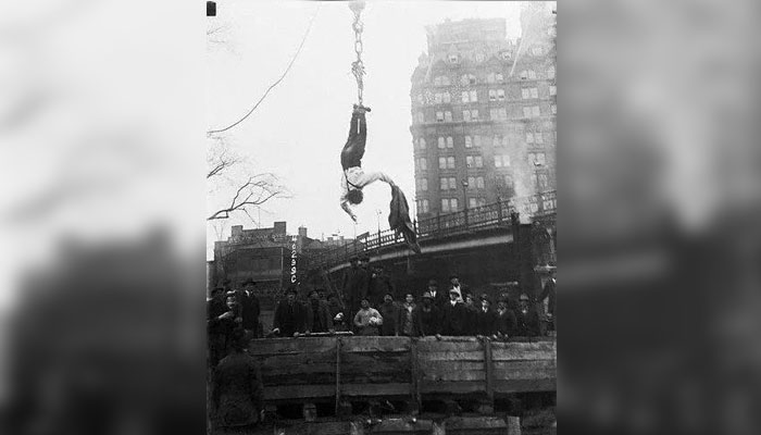 Houdini free from his hanging straitjacket trick. — Metro via Corbis