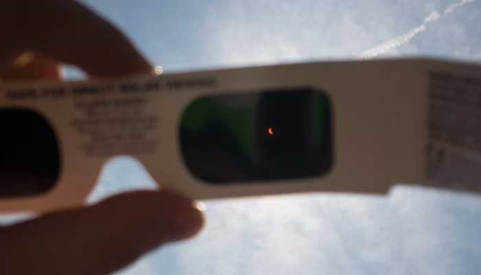 This representational image shows a view of the eclipse through eclipse glasses. — Unsplash