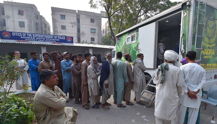 A large number of people wait outside SSP Office Sobhrab Goth, Karachi for NADRA registration. —INP/File
