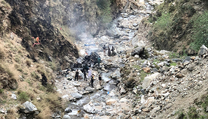 Security officials inspect the wreckage of a vehicle carrying Chinese nationals that plunged into a deep ravine after a suicide attack near Besham city in Khyber Pakhtunkhwa’s Shangla district on March 26, 2024. — AFP