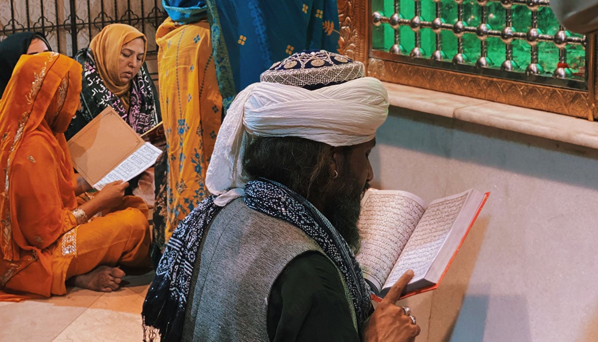 Men and women engaged in acts of praying and devotion near the mazaar in Bibi Pak Daman. — Photo by author