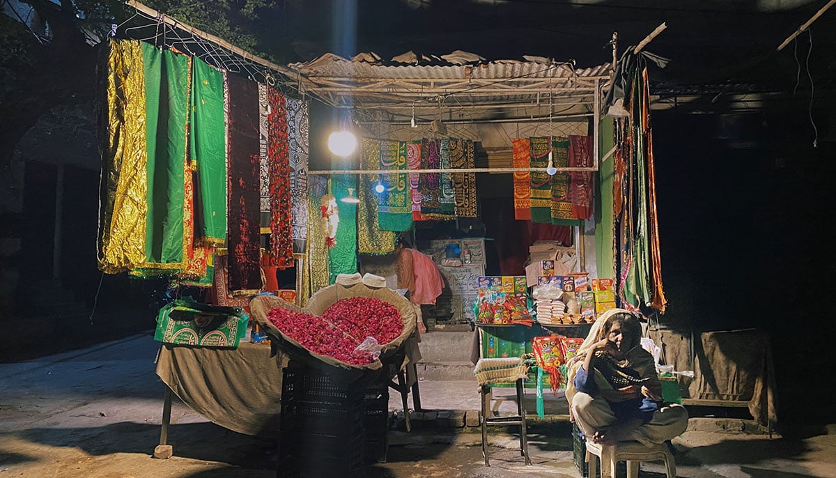Woman selling flowers, chaadar, batasha and tasbih beads at her stall outside Mian Mir shrine. — Photo by author