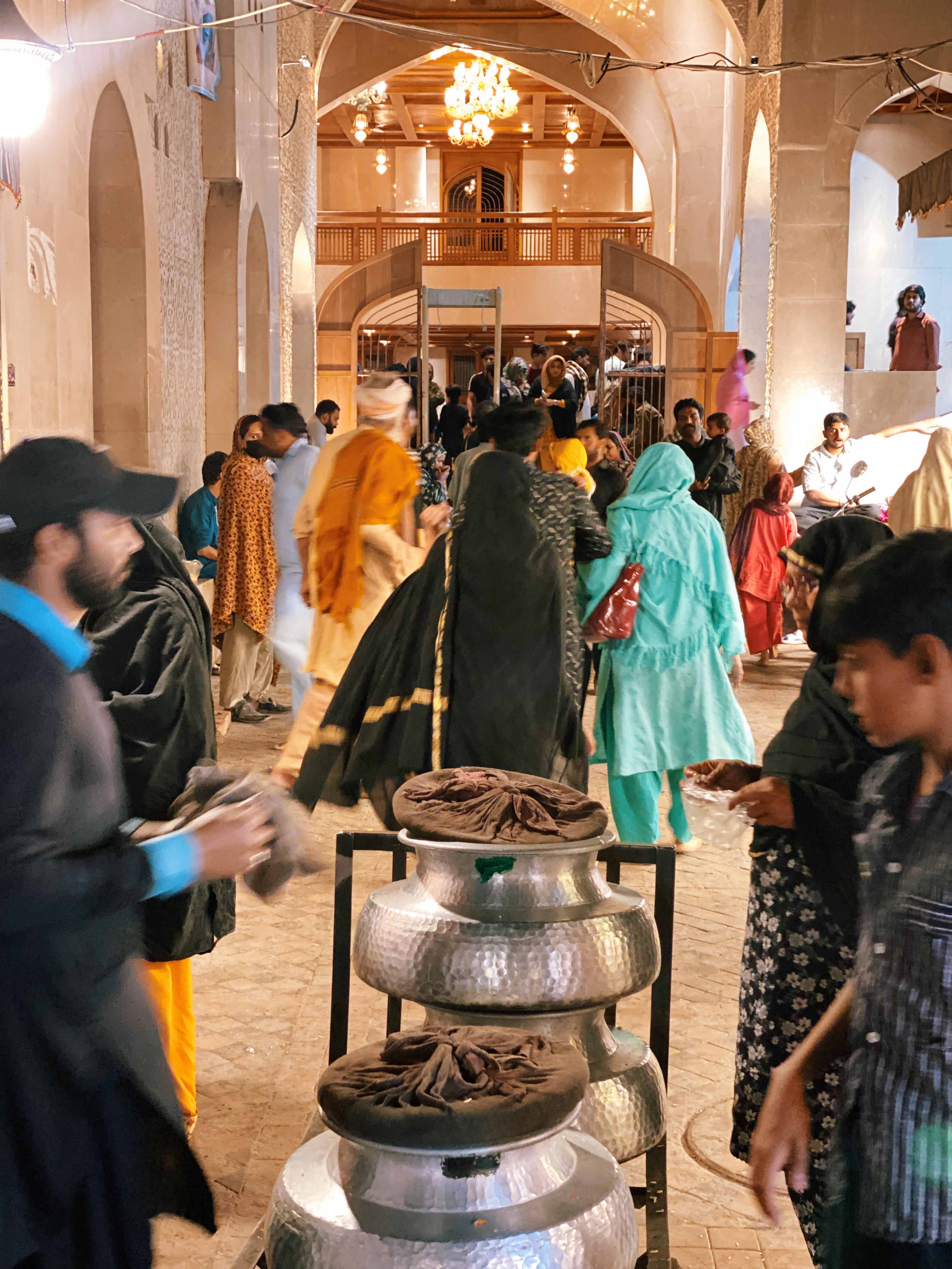 A daig of niaz being served at the entrance to Bibi Pak Daman Mazar