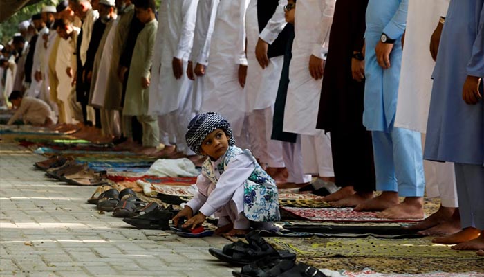 A young boy plays with sandals during the Eid ul Fitr prayer in Peshawar on May 2, 2022. — Reuters