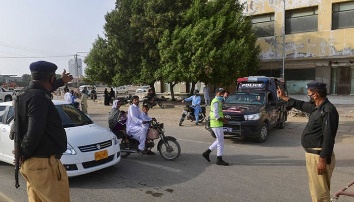A policeman stops people at a checkpoint in Karachi. — AFP/File