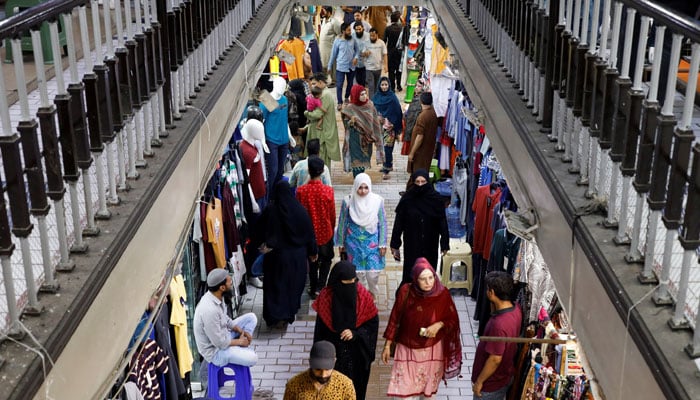 People walk as they shop in a market, ahead of Eid al-Fitr celebrations in Karachi, Pakistan April 19, 2023. — Reuters