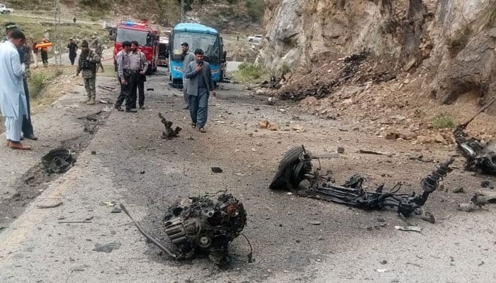 Vehicle parts can bee seen on the road in the aftermath of the deadly suicide attack on bus carrying Chinese engineers on March 26, 2024. — X/WaliKhan_TK