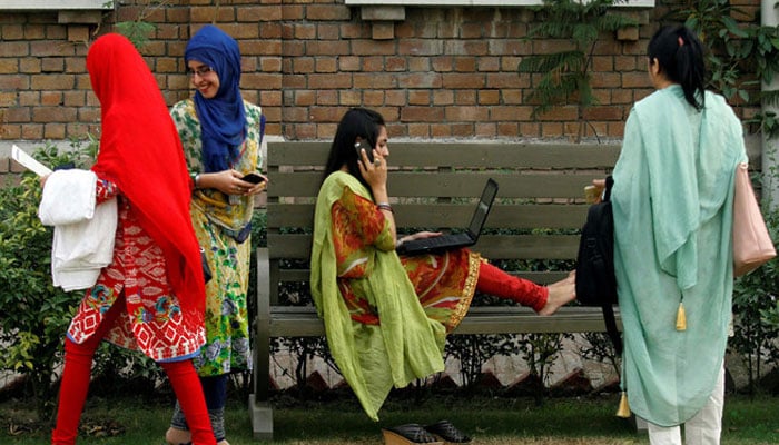 A student works on her laptop sitting on a bench at Shaheed Benazir Bhutto Womens University in Peshawar on Oct. 19, 2017. — Reuters