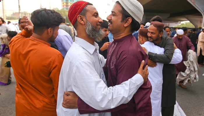 People exchange Eid greetings after offering Eid ul Fitr prayers, which mark the end of Ramadan, in Karachi on May 15, 2021. —INP