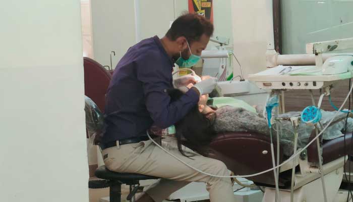 Dr Atir performing a dental procedure on his patient. — Photo by Dr Atir