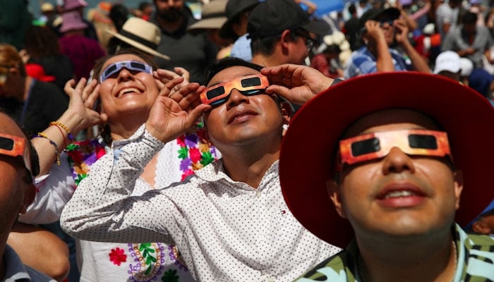 People use special protective glasses to observe a total solar eclipse in Mazatlan, Mexico April 8, 2024. REUTERS