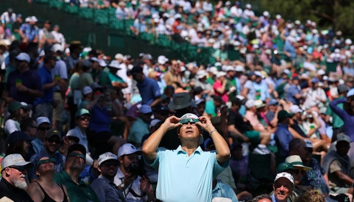 Patrons observe the eclipse during a practice round. REUTERS