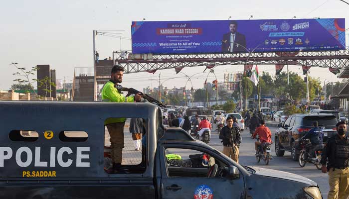 Policemen stand guard along a street in Karachi on February 1, 2024, ahead of the general elections. — AFP