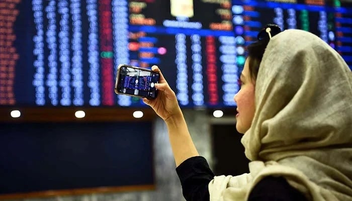 An investor can be seen taking a snap of the digital stock board at the Pakistan Stock Exchange. — Reuters/File