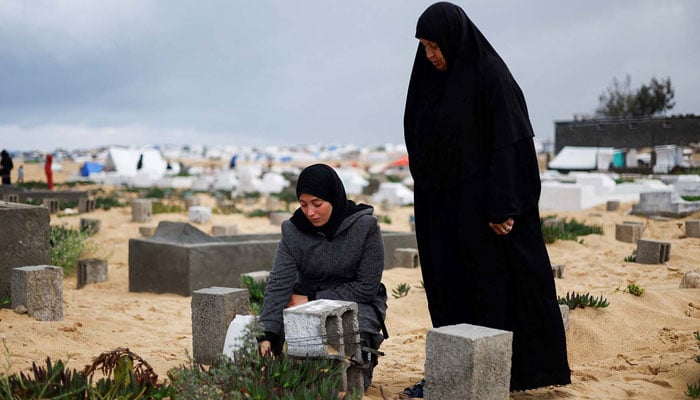 Palestinian women visit graves of people who were killed by Israeli onslaught on the day of Eid al-Fitr, in Rafah, in the southern Gaza Strip April 10, 2024. — Reuters