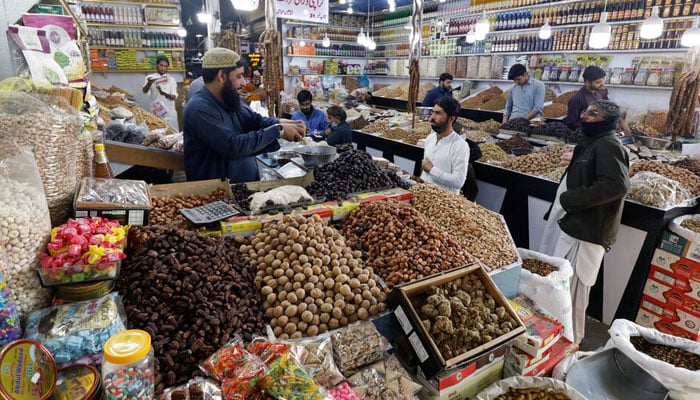 People buy dry fruits at a market in Karachi, Pakistan February 1, 2023. — Reuters