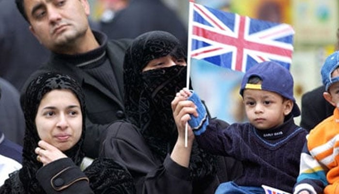 A representational image showing a UK Muslim family holding the British flag . — AFP/File