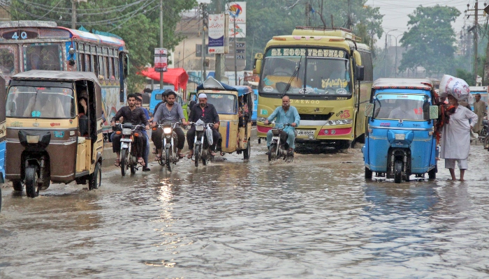 Commuters make way through flooded roads after heavy rainfall of monsoon spell in Karachi on July 24, 2023. —Online