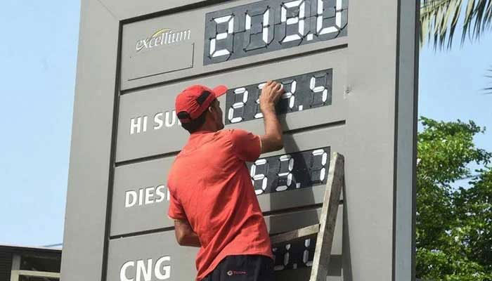 An employee of a petrol pump changing the price of petroleum products in this undated picture. — AFP/File